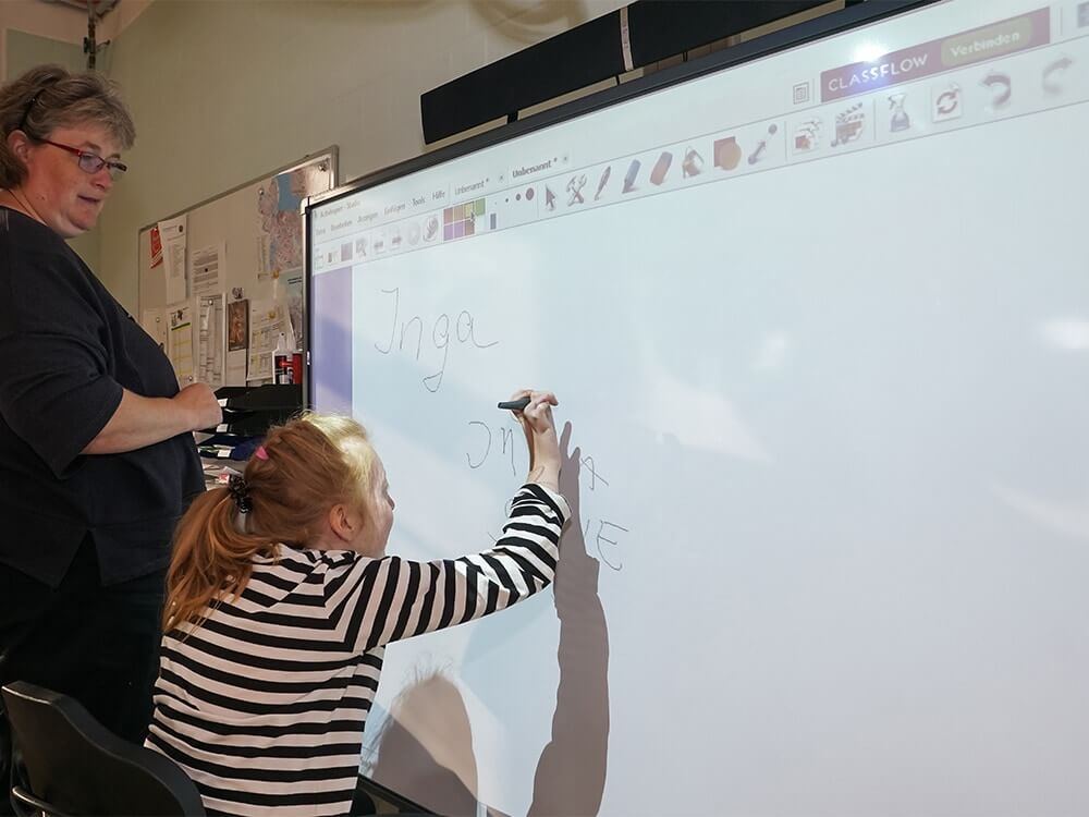 Eine Person schreibt etwas an ein Whiteboard