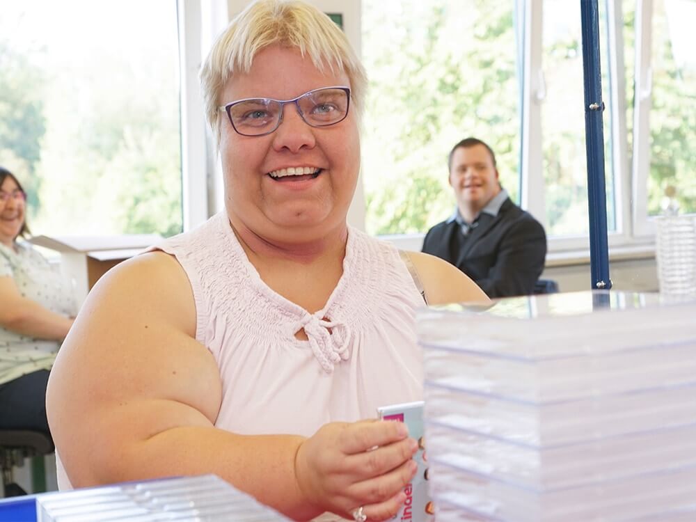 Eine Person verpackt CDs